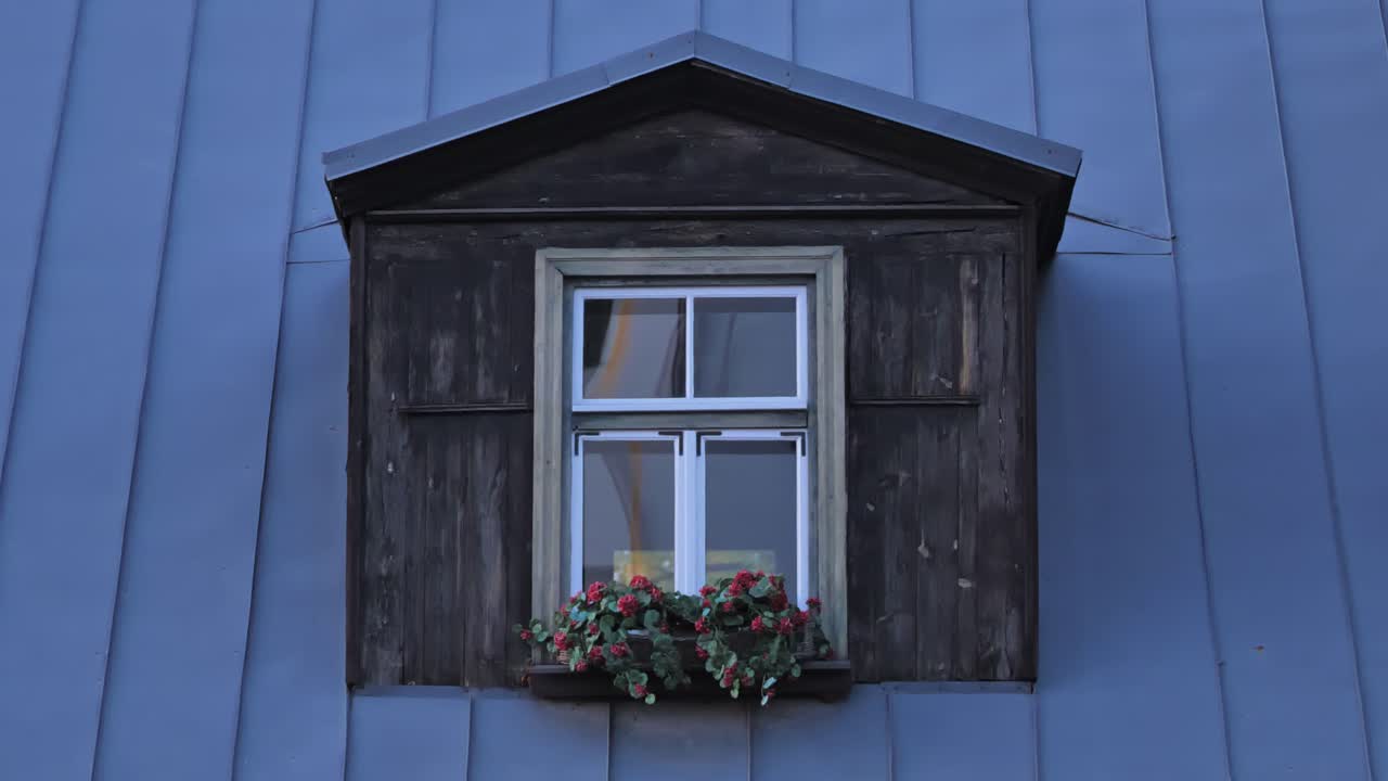 Old Wooden Dormer Window with Flower Box on Blue Metal Roof