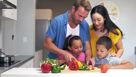 Cute-family-slicing-vegetables-in-the-kitchen