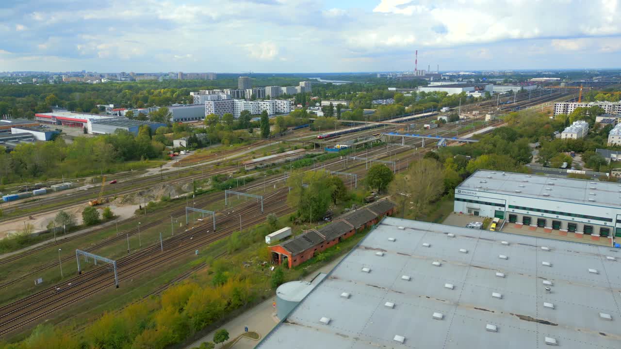 Industrial warehouse zone, urban train tracks, residential estate, aerial
