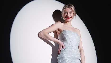 woman in a silver sparkle dress under spotlight