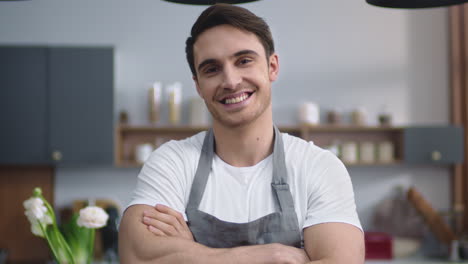 smiling chef man looking camera at home kitchen. handsome man crossing hands.