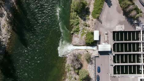 an aerial image captures treated water being released from the plant into a green-toned river, with clear water flow and facility tanks visible nearby