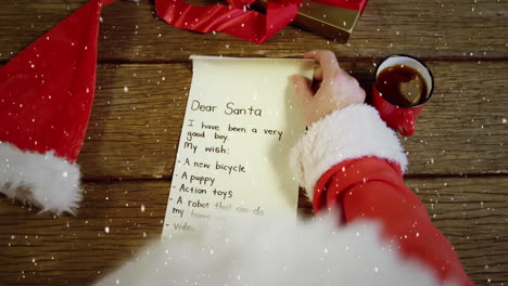 video composition with falling snow over santa  looking at wish list top view