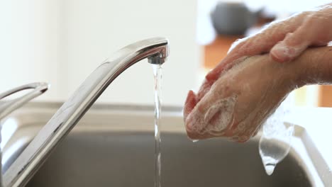 Caucasian-woman-washing-her-hands-with-soap-at-home