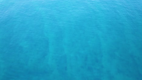 Aerial-capture-of-the-blue-ocean-with-motor-boats-near-a-coastal-city-located-on-the-shore