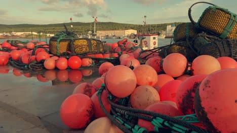 Boyas-Rojas-Vibrantes-Embellecen-Los-Muelles-De-Un-Pintoresco-Pueblo-Pesquero-Español,-Firmemente-Anclados-A-Lo-Largo-Del-Muelle-Costero.