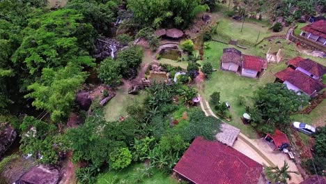 captivating 4k aerial footage of a serene waterfall area, featuring a river and wooden bridges, surrounded by lush green forests. people enjoy the water, making this video ideal for nature