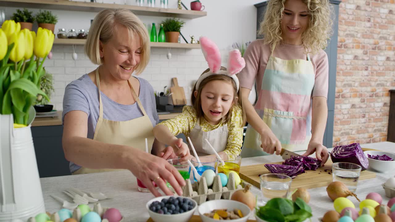Static video of grandmother with granddaughter coloring eggs