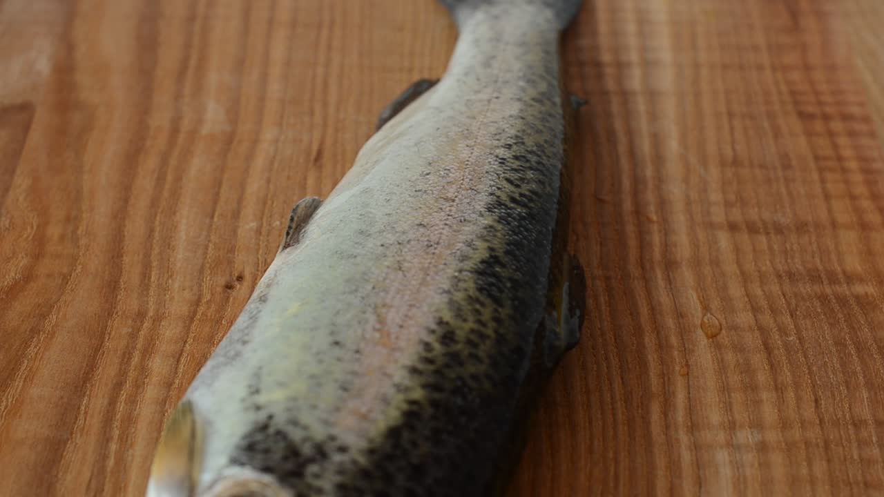 Trota su un tagliere. Riprese di pesce
