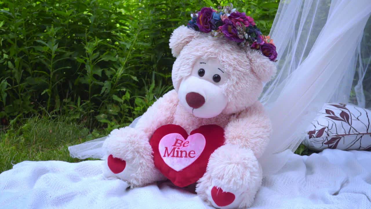 Orso rosa con decorazioni floreali. Orsetto bianco giocattolo. Orsetto di peluche