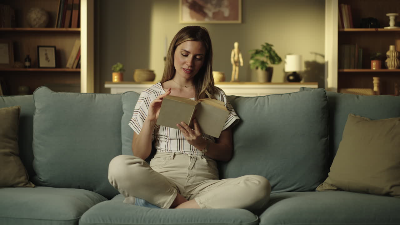 Mujer leyendo un libro en un sofá