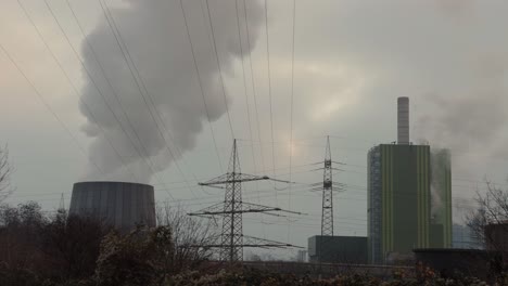 Powerlines-leading-to-large-industry,-cloudy-sky,-low-angle