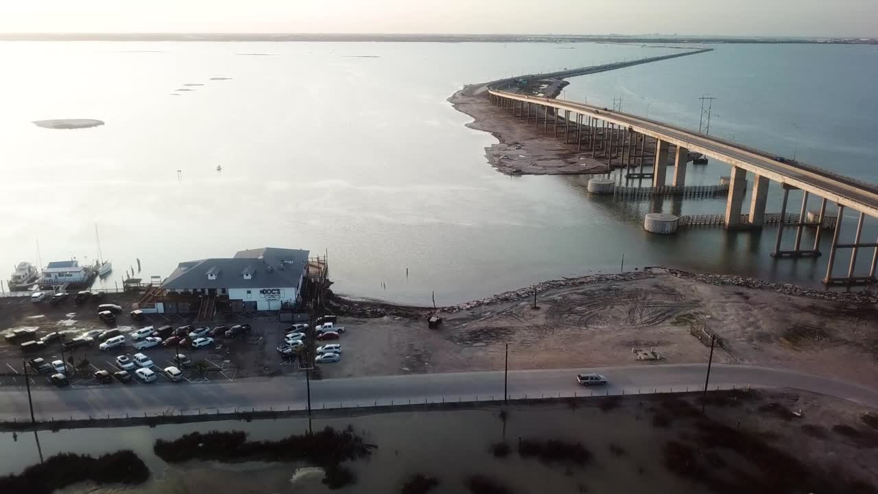 sobrevuelo aéreo de un restaurante romántico con vistas a la puesta de sol en laguna madre cerca del puente en la autopista jfk memorial en la isla del padre norte cerca de corpus christi, texas