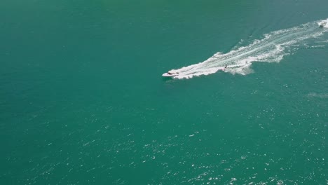 Tracking-aerial:-surfer-waterskiing-on-beautiful-jade-colored-water