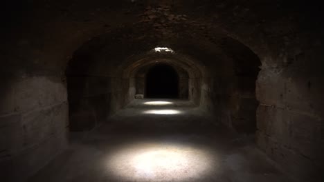 pass through a long and dark roman basement. basement under the amphitheater in el jem, tunis. ancient roman building. the camera is approaching