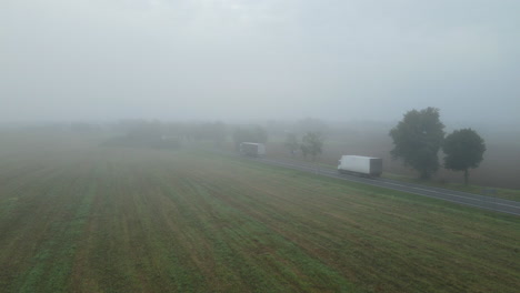 Morning-Fog-On-Fields-By-The-Asphalt-Road-With-Vehicles-Passing-By-In-Lubawa,-Poland