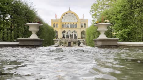 small fountain stream in front of a large beautiful historic house with a large window