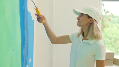 una mujer pintando una pared.