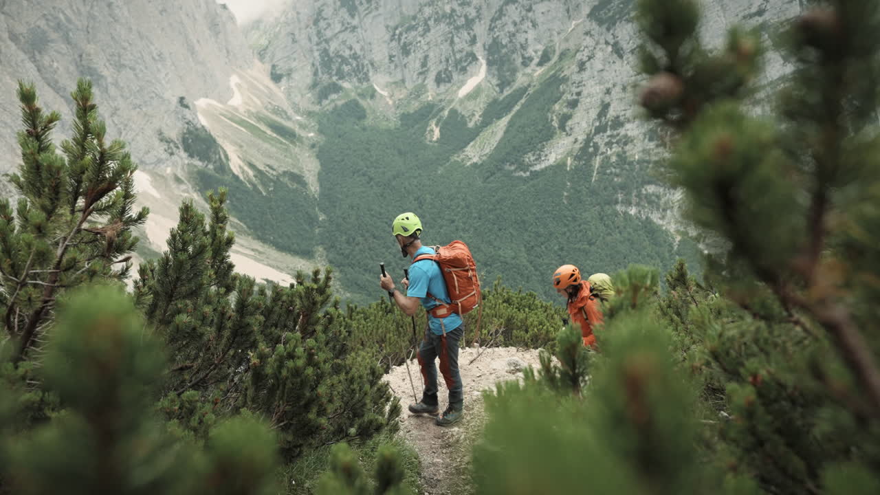 los excursionistas caminan hasta el punto de vista y señalan con bastones en una dirección