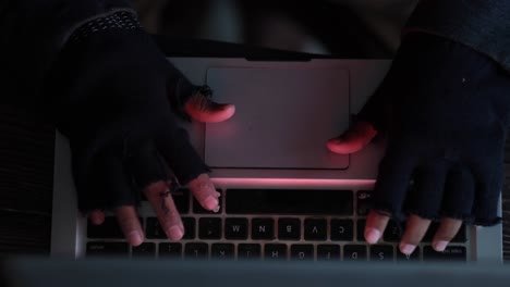 persona hacking una computadora portátil en la oscuridad