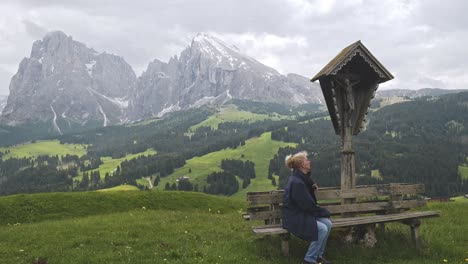 woman rests at alpine meadow scenic viewpoint of snowcapped mountain peaks