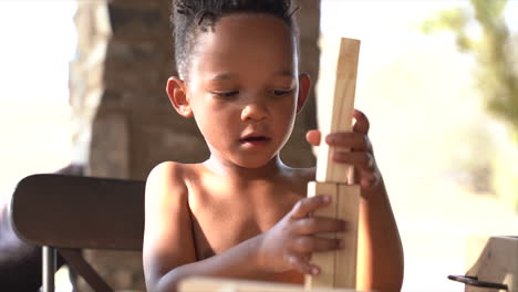 niño sudafricano de 4 años jugando con bloques y su hermana los golpea y luego se ríe