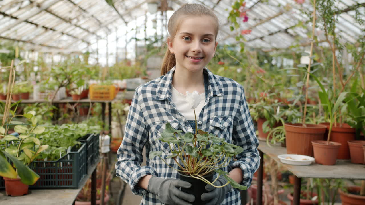 Girl with cyclamen in greenhouse