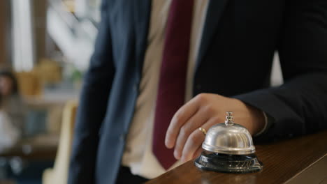 hotel receptionist pressing a service bell