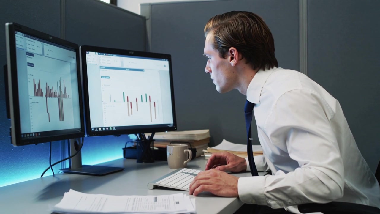 Leaning office worker in white shirt, tie scanning two screens after spotting chart, copy space