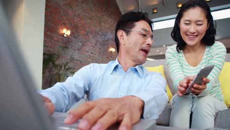 asian couple using media devices