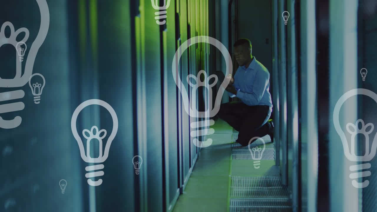 Animation of light bulbs, african american male engineer checking data server rack in server room