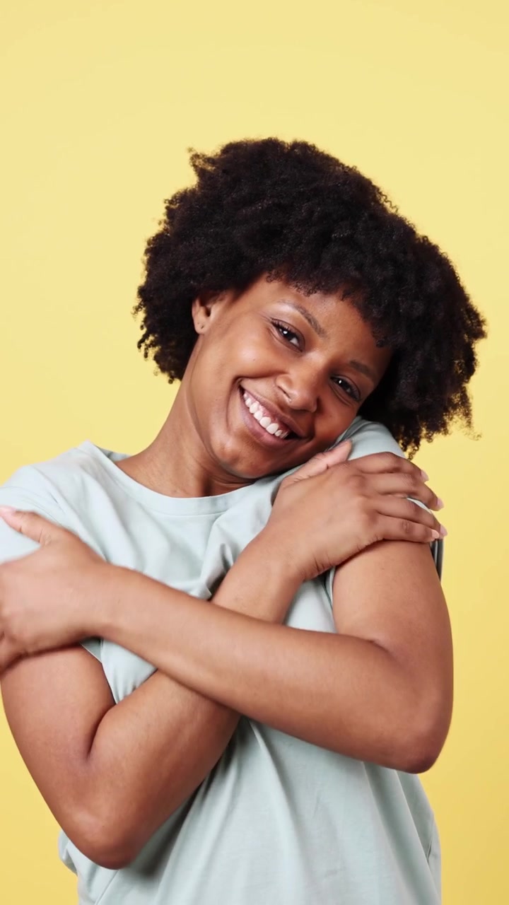 Donna afroamericana felice che si abbraccia con un sorriso