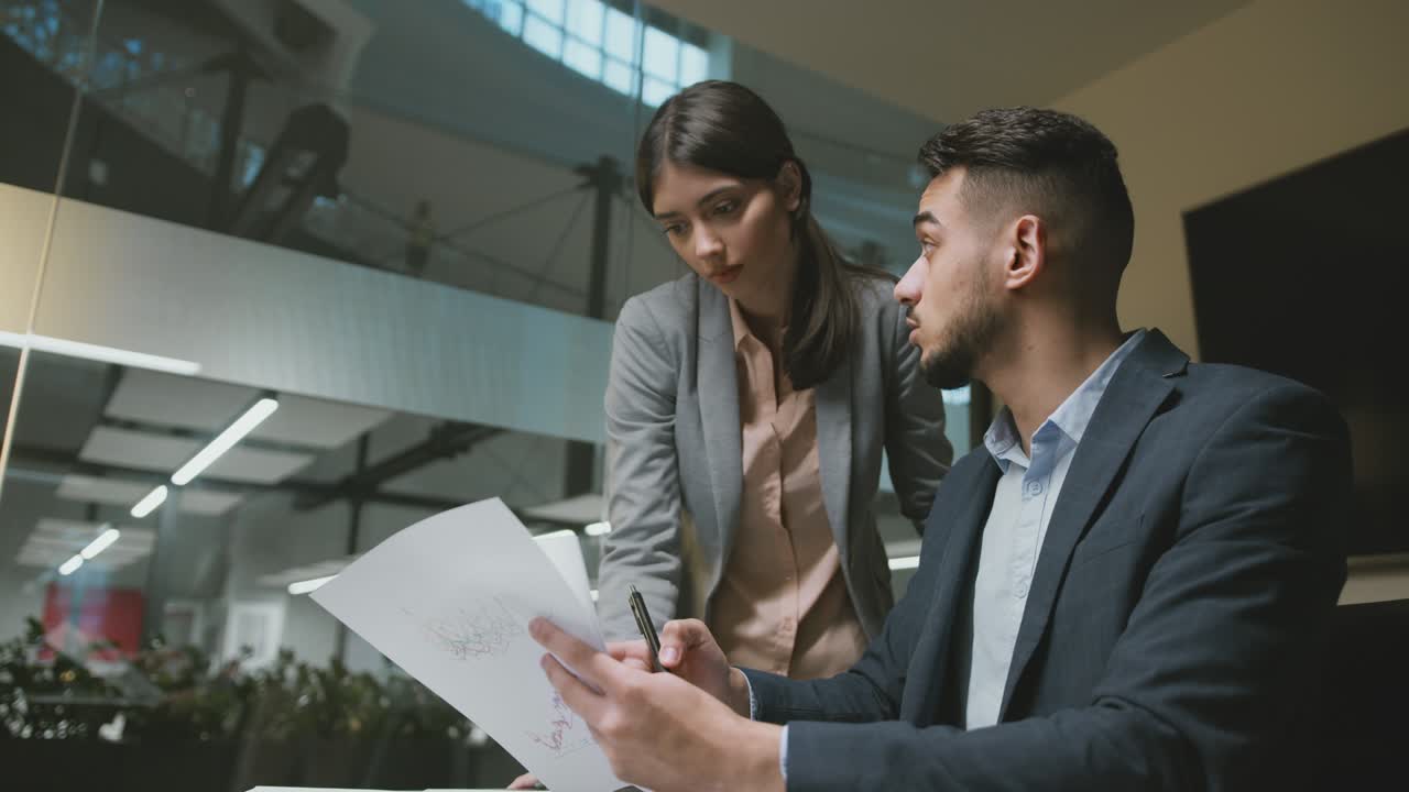 período de prueba en el trabajo. joven líder de equipo de oriente medio explicando los detalles del proyecto a una mujer recién llegada