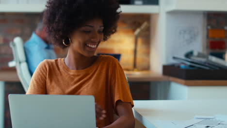 Joven-Empresaria-Sonriente-Trabajando-En-Una-Computadora-Portátil-En-El-Escritorio-De-La-Oficina-Hablando-Por-Teléfono-Móvil