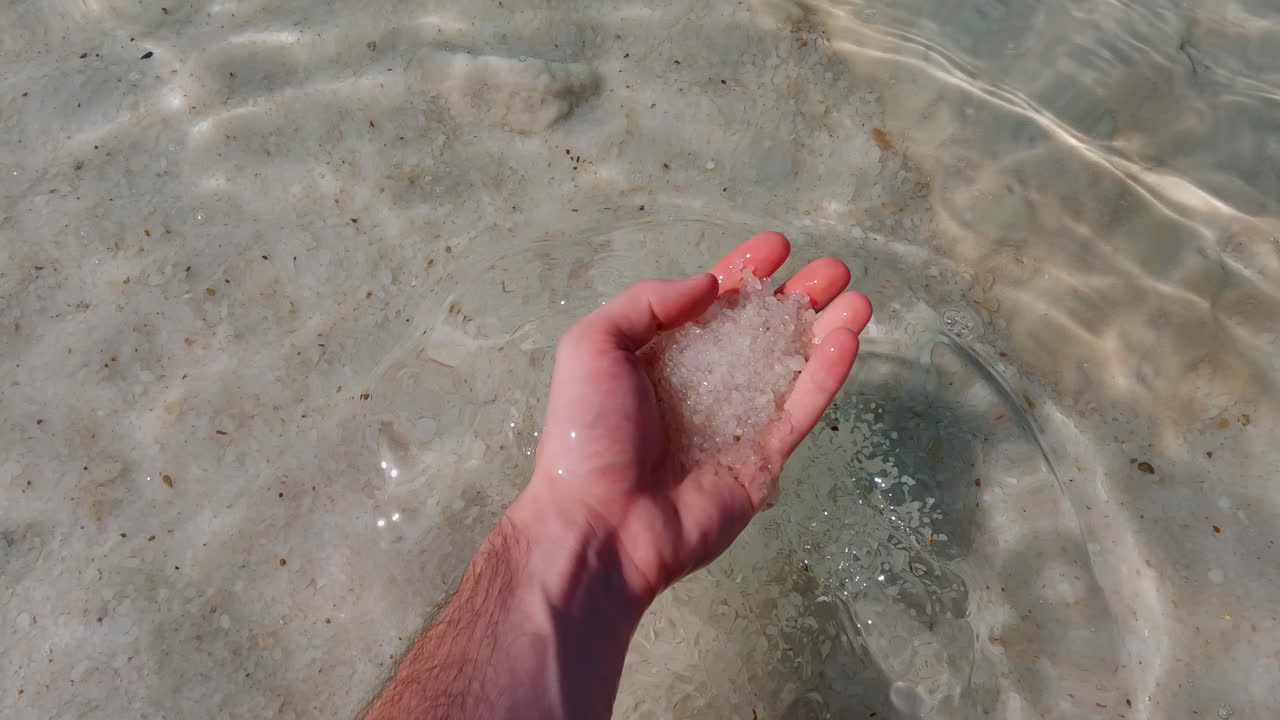 la mano del macho agarra la espesa sílice la arena salada del mar muerto se levanta para ver