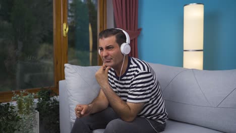 Unhappy-man-listening-to-music-with-headphones.