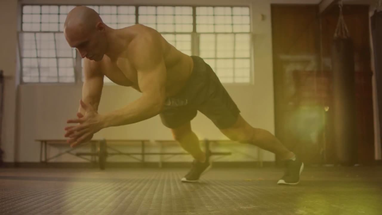 Allenatore uomo che parte dalla posizione di plank, eseguendo flessioni alternate con allungo per il fitness, con effetto bokeh.