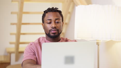 hombre trabajando en una computadora portátil en casa