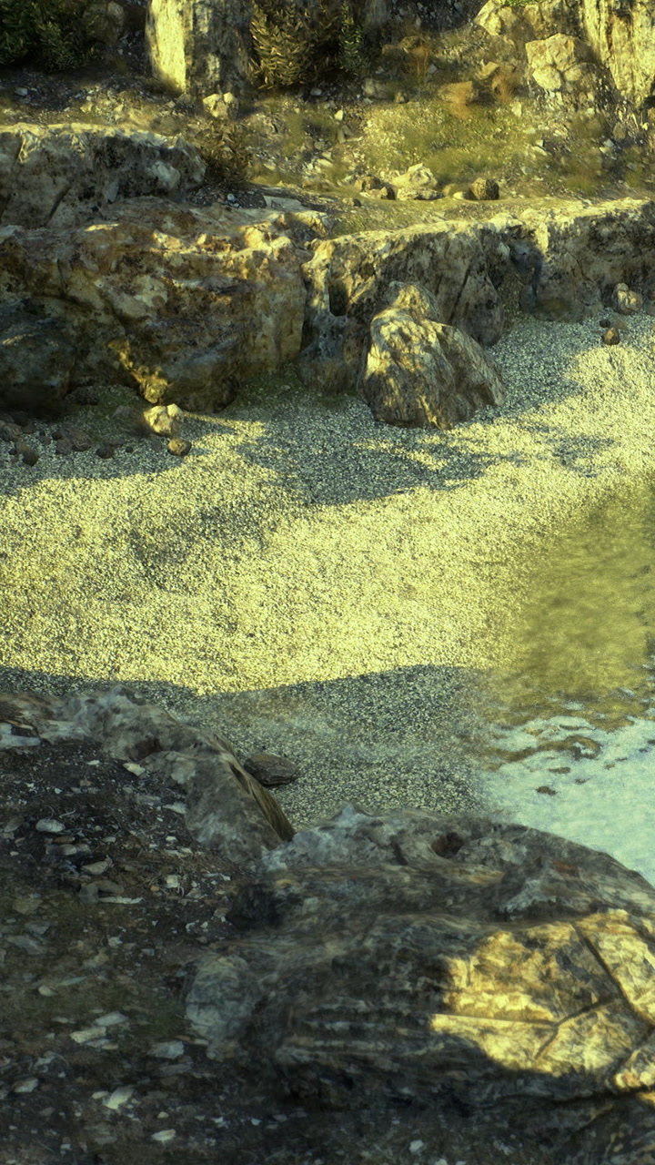 View of rocks and pebbles by water in natural setting during daytime hours