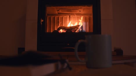 Fondo-Acogedor-De-Un-Viejo-Cuaderno-Y-Una-Taza-Con-Vapor-Caliente-Saliendo-De-él,-Cerca-De-Una-Cálida-Chimenea