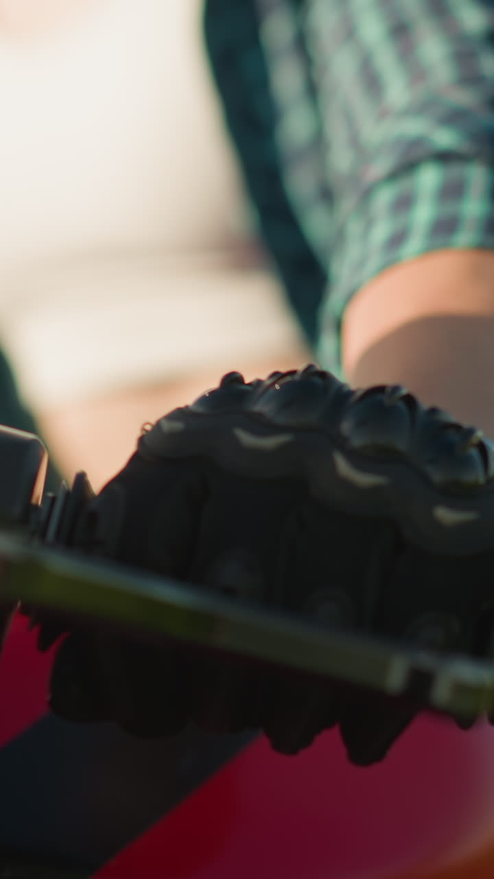 primer plano de una mujer con una camisa a cuadros verde, una camiseta blanca y guantes de protección estrangulando una motocicleta roja