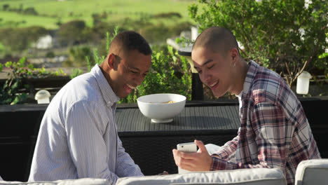 friends discussing and using a smartphone on a rooftop