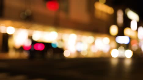 luces borrosas de la ciudad con vehículos en movimiento por la noche