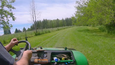 riding in a off-road vehicle in a wide grassy area surrounded by a field and wooded area