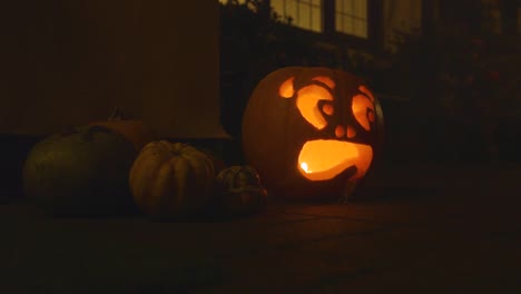 1 carved lit pumpkin outside the front of a house halloween with smoke