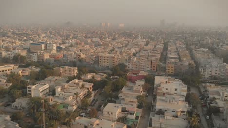 aerial over smog filled karachi with train going past below