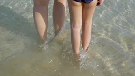 Mother-and-kid-walking-into-pure-sea-water