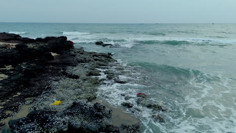 las olas salpicando las rocas de la orilla del mar