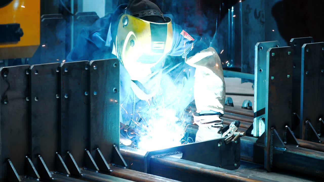 Welder working with welding machine in protective mask. Hazardous work