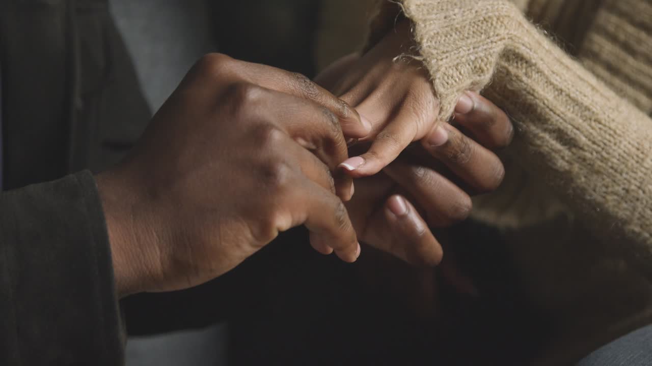 Close Up Of Man Putting Engagement Ring On Woman's Finger As He Proposes Marriage